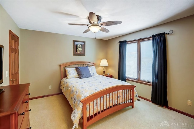 bedroom with light carpet, baseboards, and a ceiling fan