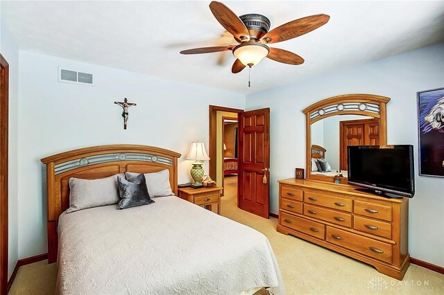 bedroom featuring a ceiling fan, light colored carpet, visible vents, and baseboards