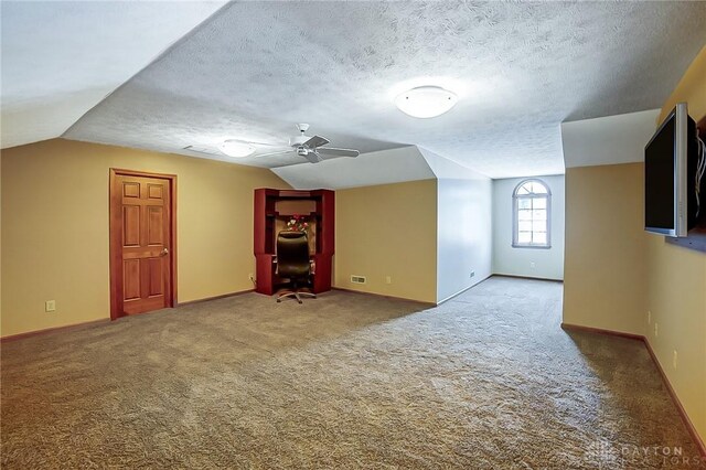 bonus room with carpet floors, lofted ceiling, visible vents, and a textured ceiling