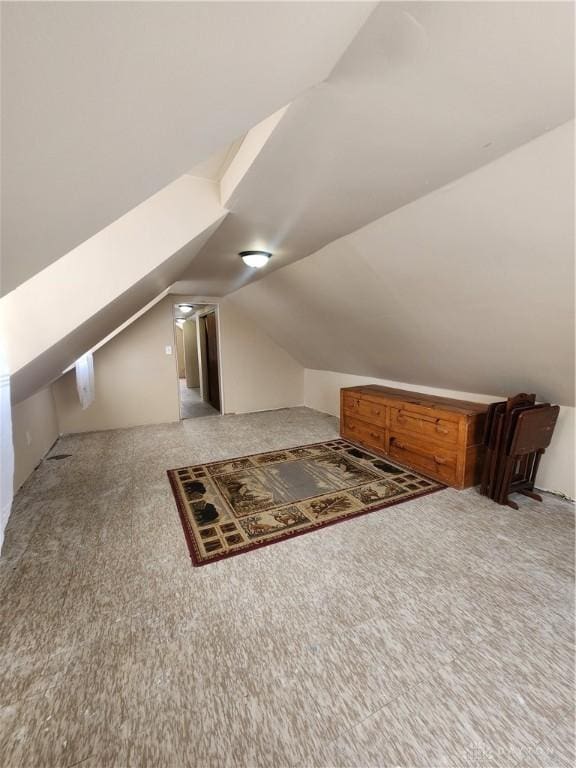 bonus room featuring light colored carpet and vaulted ceiling