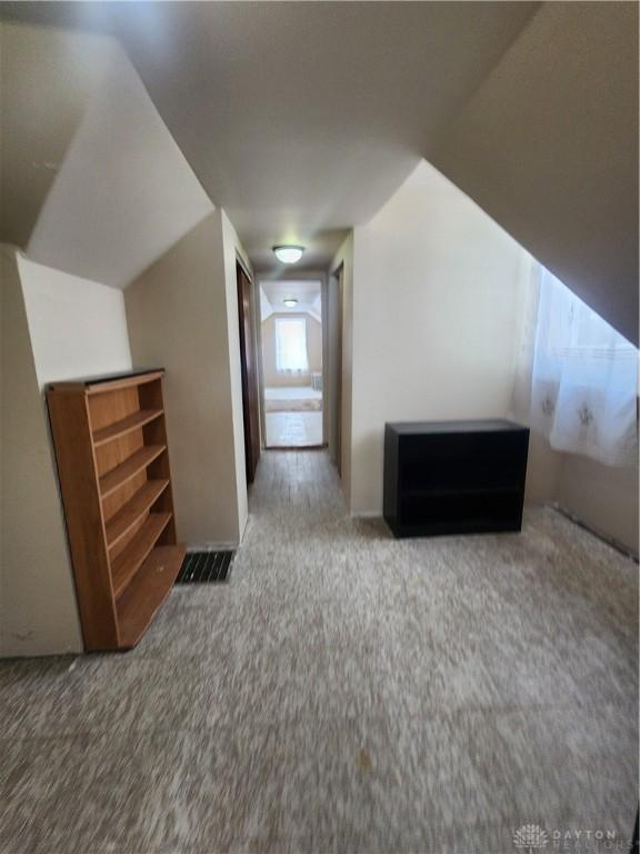 bonus room featuring visible vents and carpet flooring