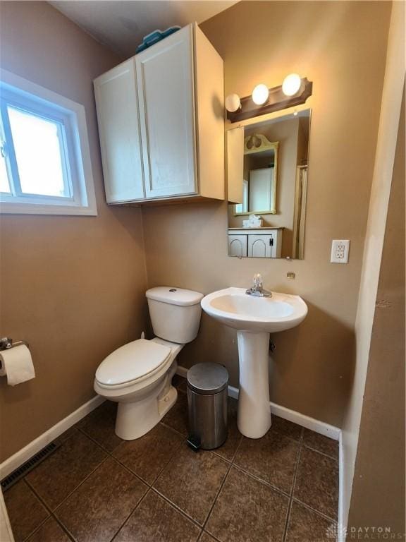 bathroom with tile patterned flooring, visible vents, toilet, and baseboards