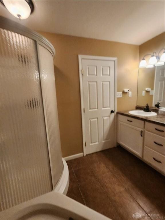 bathroom featuring tile patterned flooring, baseboards, and vanity