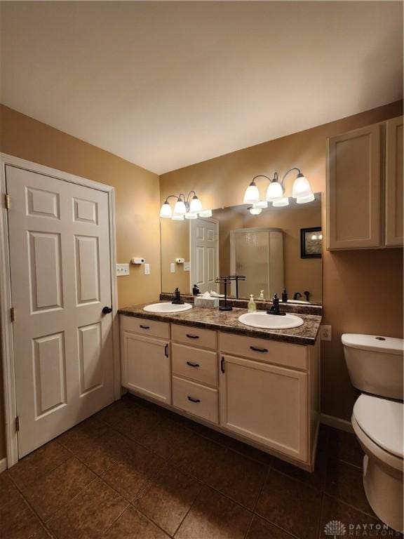 full bathroom with tile patterned flooring, a sink, toilet, and double vanity