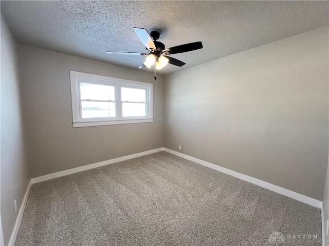 empty room with carpet, baseboards, ceiling fan, and a textured ceiling