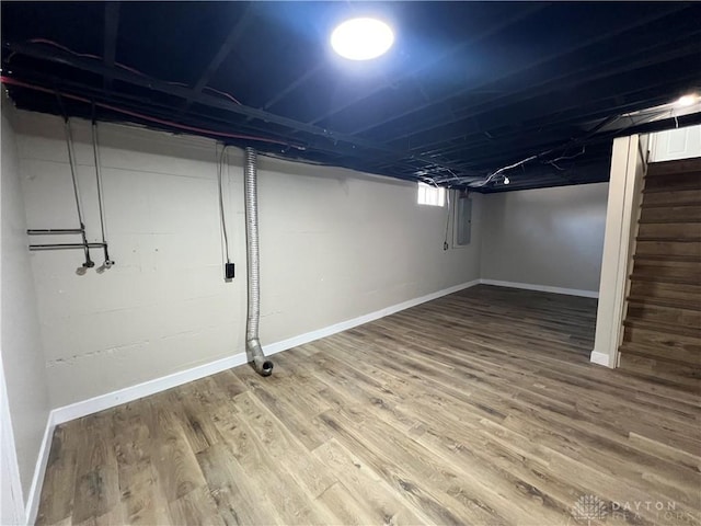 basement featuring stairs, wood finished floors, and baseboards