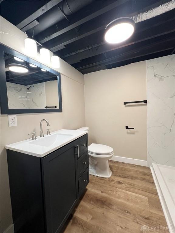 full bathroom with toilet, baseboards, wood finished floors, and vanity