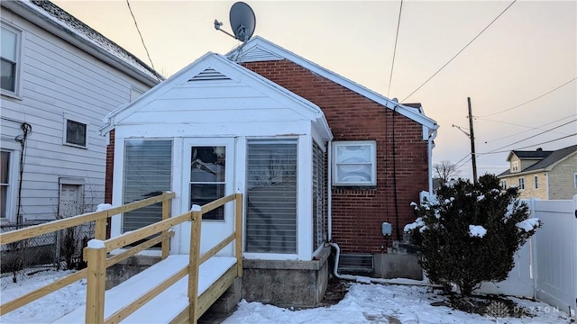 view of front of home with brick siding and fence