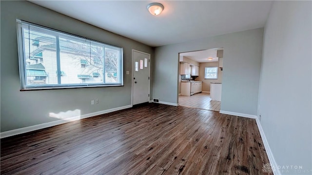 interior space with dark wood-type flooring and baseboards