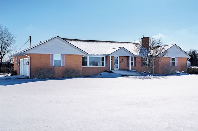 ranch-style house featuring brick siding and a chimney