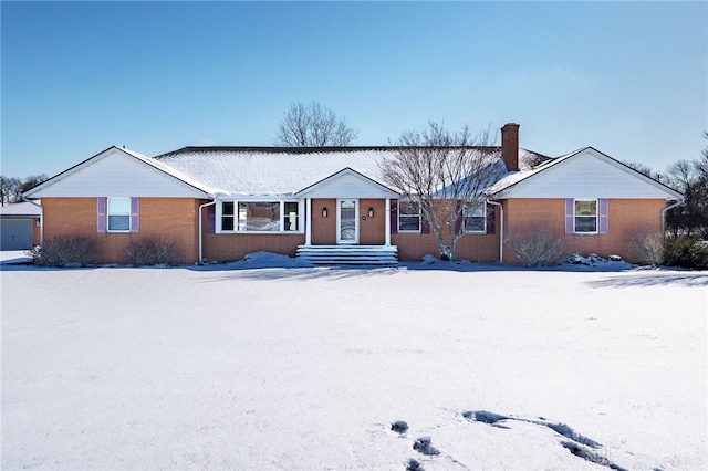 single story home featuring a chimney and brick siding