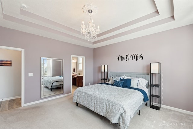 bedroom featuring a raised ceiling, a notable chandelier, and light colored carpet