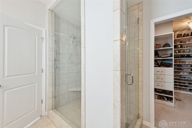 bathroom with a spacious closet and a stall shower