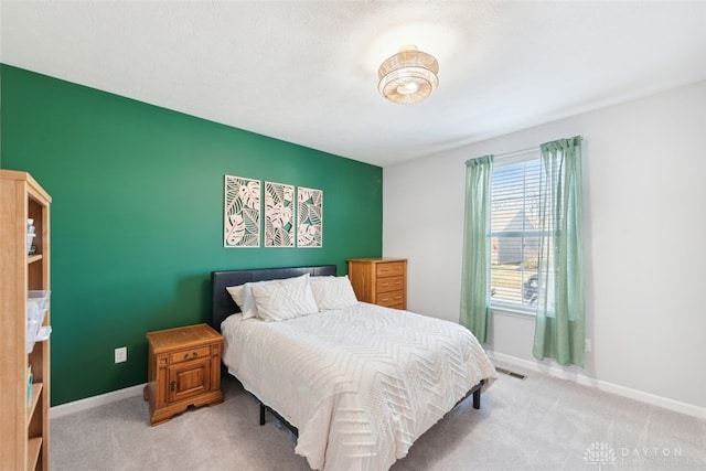 bedroom with light carpet, visible vents, and baseboards