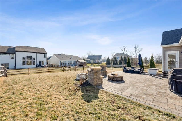 view of yard with an outdoor fire pit, a fenced backyard, a patio, and a residential view