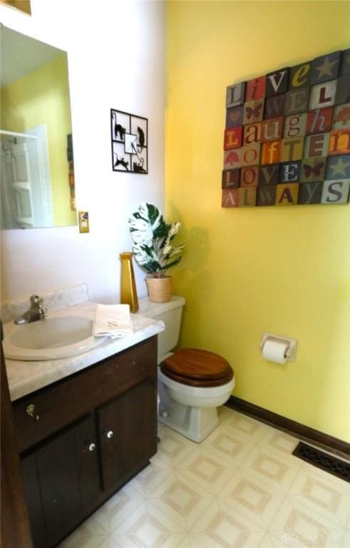 bathroom with toilet, tile patterned floors, baseboards, and vanity