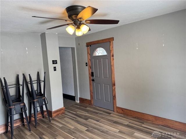 foyer with dark wood finished floors and baseboards