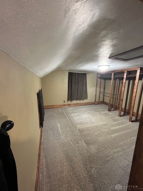 bonus room featuring carpet flooring, vaulted ceiling, a textured ceiling, and baseboards