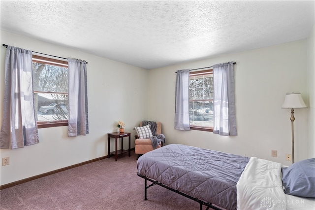 carpeted bedroom featuring multiple windows, baseboards, and a textured ceiling