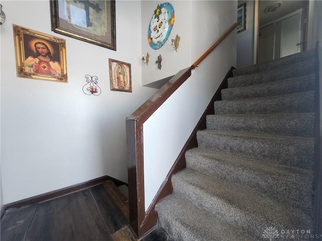 stairway featuring baseboards and wood finished floors