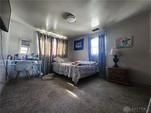 bedroom featuring dark colored carpet and visible vents