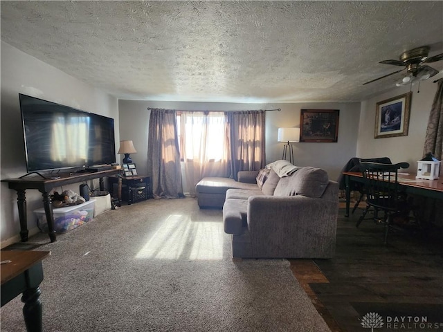 living room featuring carpet floors, ceiling fan, and a textured ceiling