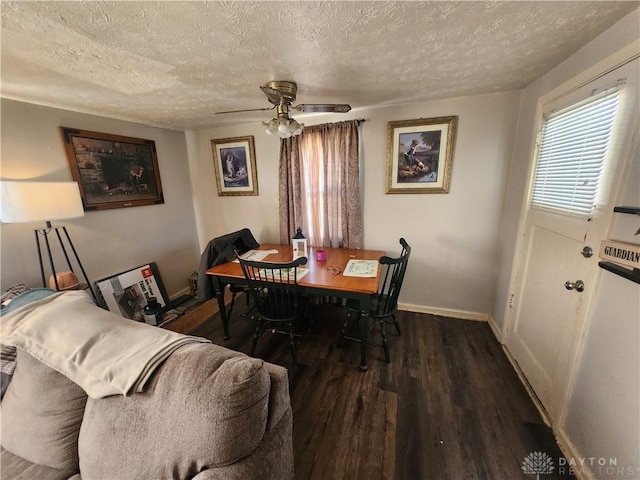 dining space with a textured ceiling, ceiling fan, dark wood-type flooring, and baseboards