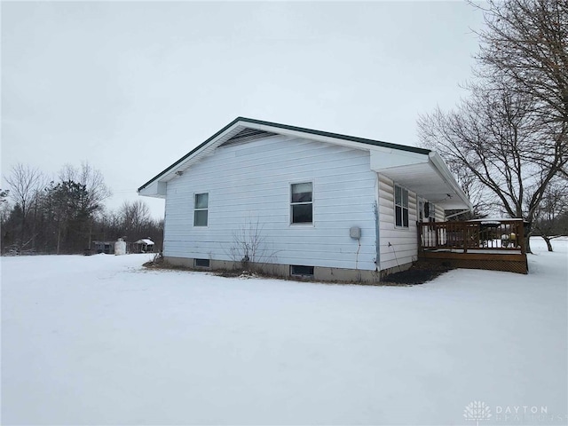 snow covered property featuring a wooden deck