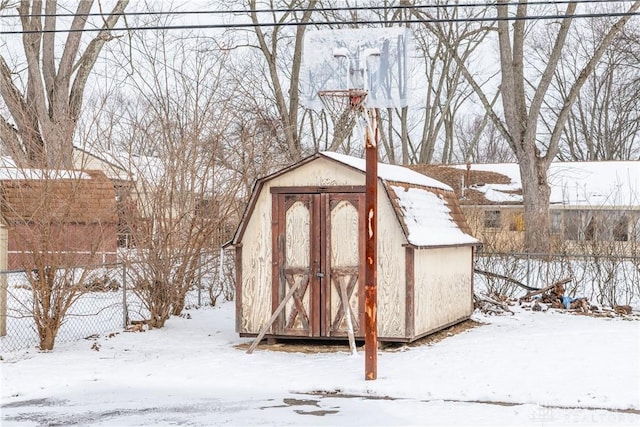 snow covered structure featuring a storage unit