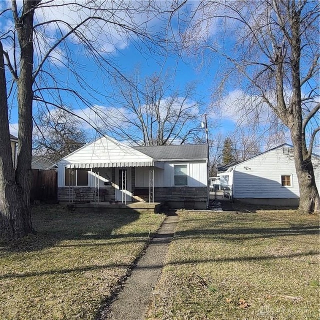 view of front of home featuring roof with shingles, a front yard, and board and batten siding