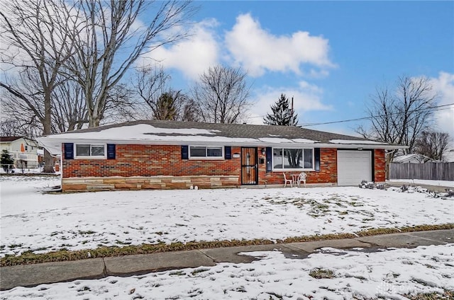 ranch-style home featuring a garage, brick siding, and fence