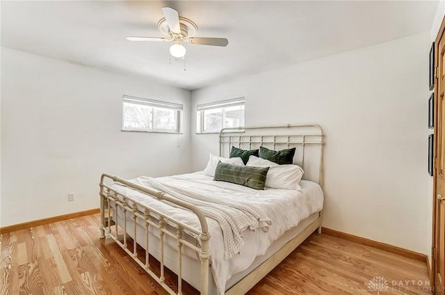 bedroom featuring a ceiling fan, light wood-type flooring, and baseboards