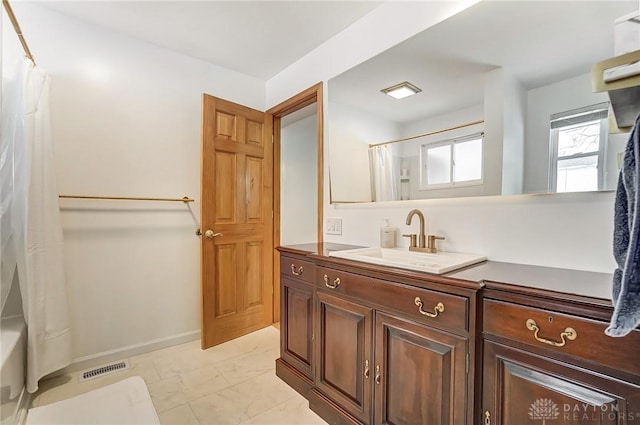 bathroom featuring visible vents, vanity, baseboards, marble finish floor, and shower / bath combo with shower curtain