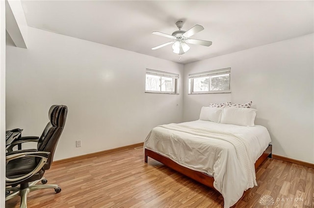 bedroom with ceiling fan, light wood-style flooring, and baseboards