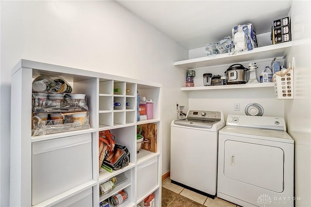 clothes washing area with laundry area, light tile patterned floors, and separate washer and dryer