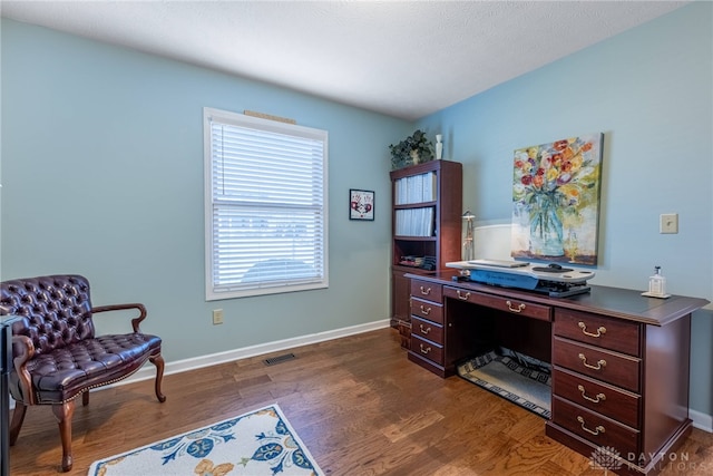 office area with visible vents, baseboards, and dark wood-type flooring