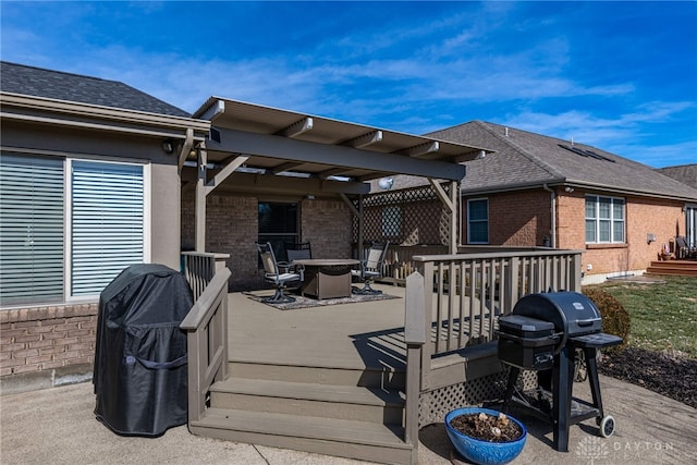 deck with a fire pit, a pergola, and area for grilling