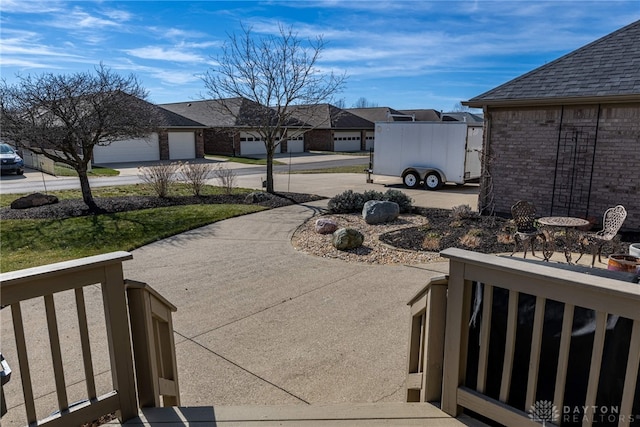 view of patio with a residential view and concrete driveway