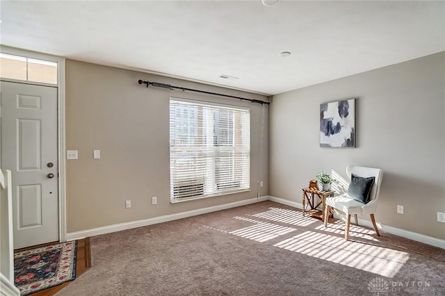 living area featuring carpet flooring, visible vents, and baseboards