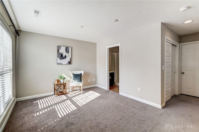 unfurnished room with carpet floors, visible vents, and baseboards