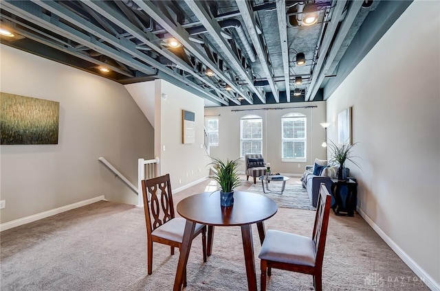 carpeted dining space with baseboards