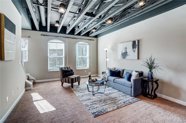 carpeted living area featuring plenty of natural light, stairway, and baseboards