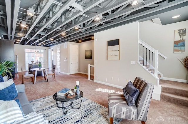 living room with baseboards, stairway, and carpet flooring