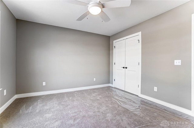 unfurnished bedroom with a closet, baseboards, ceiling fan, and carpet