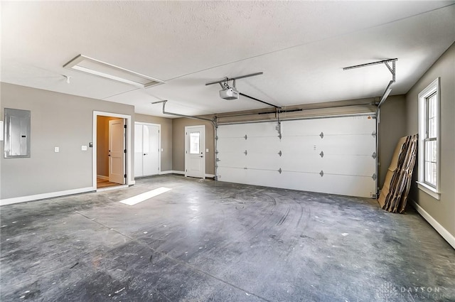 garage featuring a garage door opener, baseboards, and electric panel