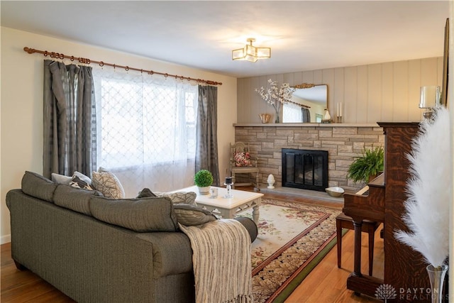 living area featuring wood finished floors and a stone fireplace