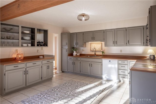 kitchen with gray cabinets, white dishwasher, a sink, and light tile patterned floors