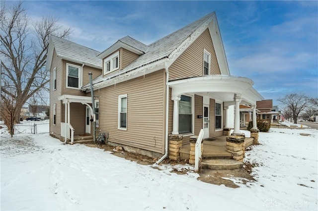 view of snowy exterior featuring covered porch