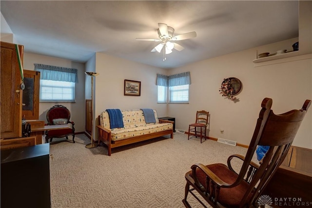 living area with visible vents, baseboards, carpet, and ceiling fan