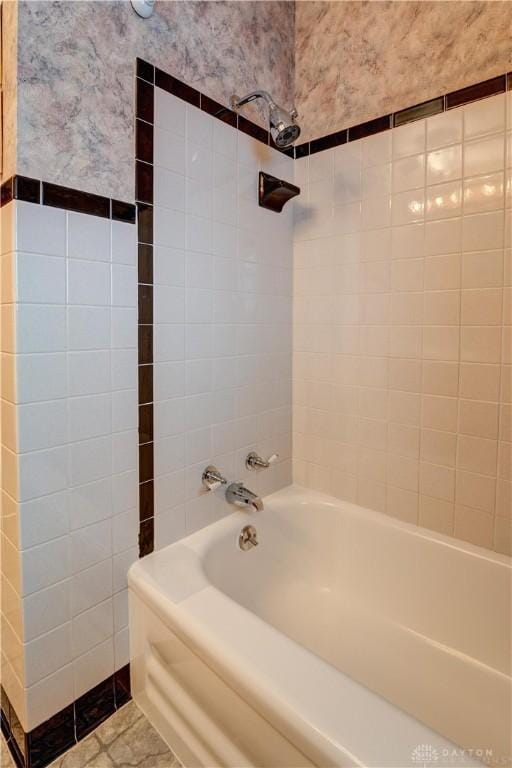 full bathroom with tile patterned floors, tile walls, shower / washtub combination, and wallpapered walls